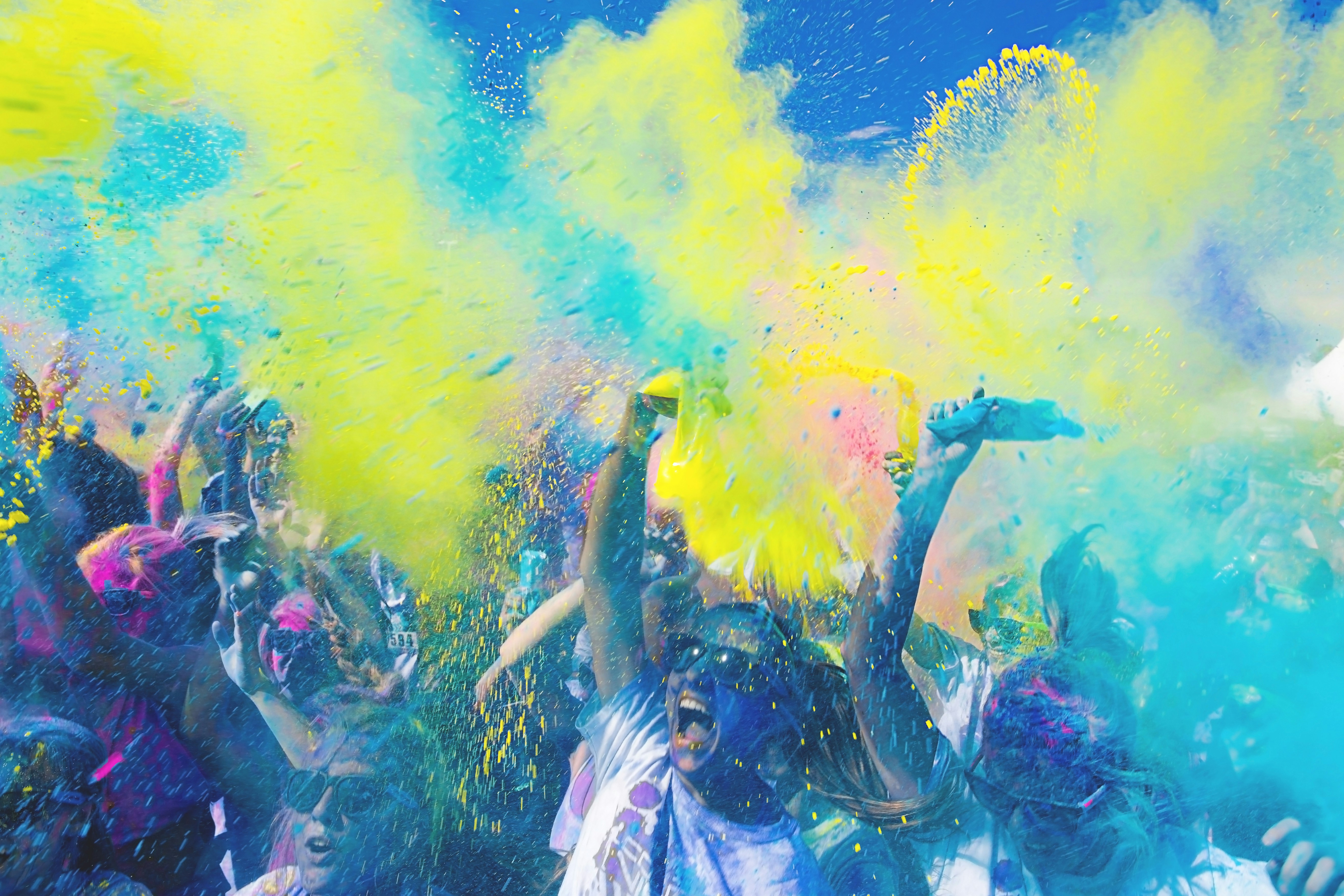 Colourful crowd celebrating at an outdoor colour run